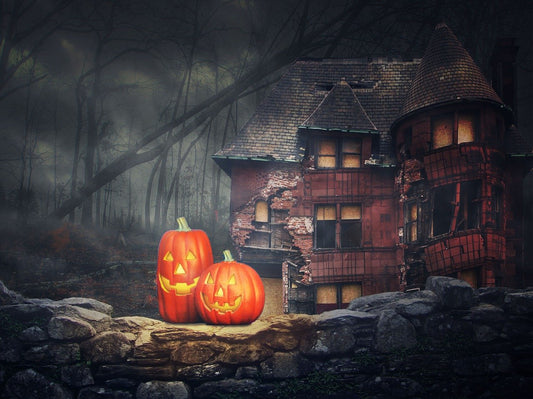 Two pumpkins perch next to a haunted mansion.